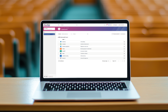 Laptop in een aula met het AIM-dashboard van Academic Software voor realtime beheer van leerlingenlaptops.